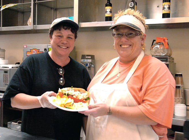 Debbie Silvia and Patti O'Brien with one of ther lobster rolls at the their resturant at Government Center. Souza photo 6.26.09