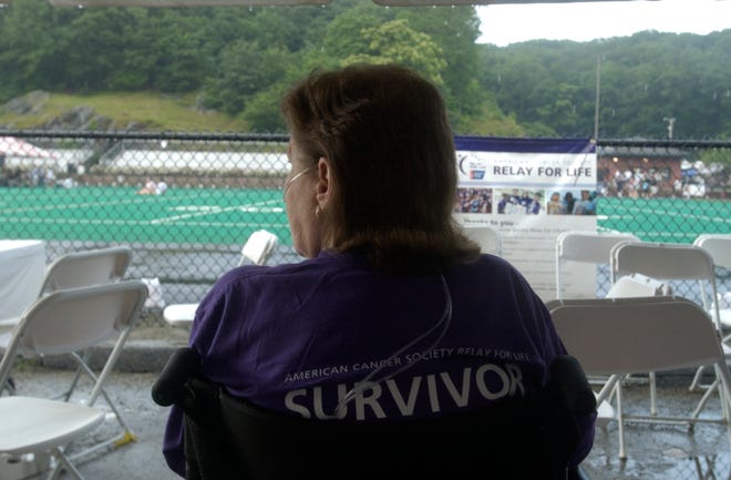 Lurlene Madsen, 59, of Quaker Hill, lung cancer survivor watches the Relay for Life walkers as a sudden rain storm washes over Norwich Free Academy's track. Madsen is part of the "Happy Chappy" Relay for Life team.
Photo by Dieu To/ Norwich Bulletin