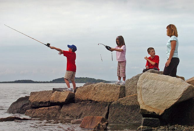 Ellie O’Malley, far right, looks on as, from left, Curran Archer, 9, Mave Ritchie, 6, and Declan Ritchie, 8, fish at Quincy’s Merrymount Beach on a recent afternoon.