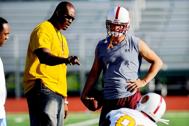 Columbia Trojans Coach J.D. Franklin talks with former Missouri basketball player Jason Sutherland and other players during a practice earlier this week at Rock Bridge High School. Sutherland quarterbacks Columbia’s adult amateur football team, which also includes former MU football player Jason Simpson and a number of players who once suited up for Hickman and Rock Bridge.
