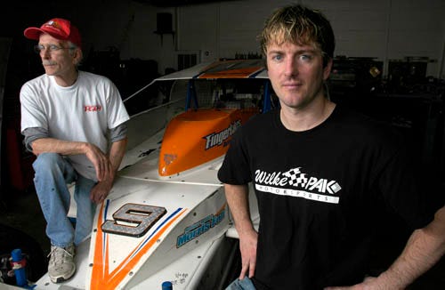 Tim McCreadie, right, and his father, Bob, pose at the family garage in Watertown, N.Y., Saturday May 9. Tim McCreadie is planning a return to racing after recovering from a broken back.