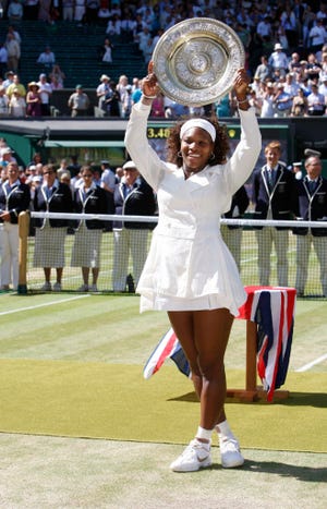 Serena Williams holds the championship trophy, after she defeated her sister Venus to win the women's singles final on the Centre Court at Wimbledon, Saturday, July 4, 2009.AP Photo/Kirsty Wigglesworth