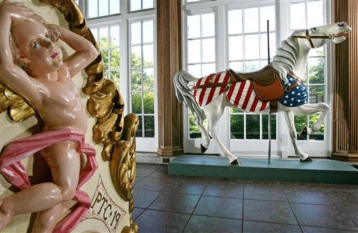 A carousel horse (right) that spun for 60 years at Euclid Beach Park that is displayed at the Western Reserve Historical Society in Cleveland. Forty years after the amusement park closed forever, loyal fans want to bring the carousel back. (AP Photo/The Plain Dealer, Lonnie Timmons III)