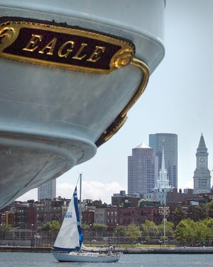 The Boston skyline is visible beyond the stern of the Eagle, a 295-foot, three-masted U.S. Coast Guard ship, tied up at the Charlestown Navy Yard. The steel-hulled vessel was built for sail training in Germany in the 1930s and was included in reparations paid to the U.S. after World War II. It is now the only active commissioned sailing vessel in the U.S. maritime services. The Sail Boston celebration of Tall Ships will continue through Sunday, and visitors may board ships at Charlestown, the Fish Pier, and the World Trade Center.