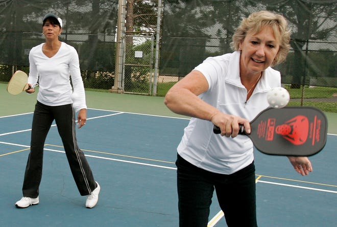 Shalda Nelson (right) returns the ball while playing pickleball with Pat Powelson on Thursday, July 9, 2009, at Guilford Tennis Center in Rockford.