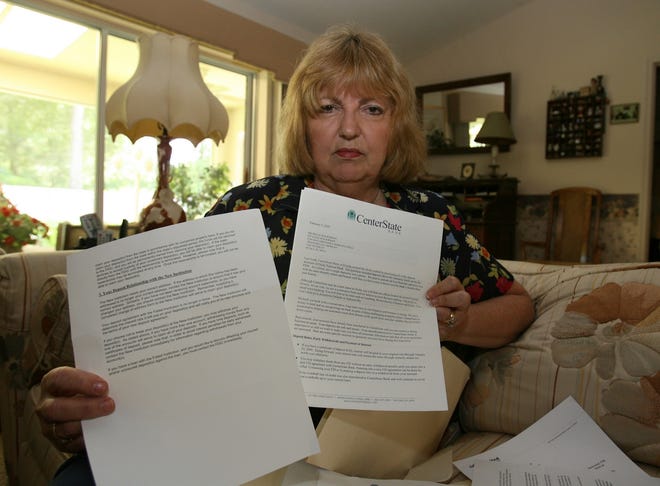 Michelle Rockman poses with two letters she received in the mail, one from the FDIC, left, and another from CenterState Bank, right, at her home on Northeast Eighth Street in Ocala on Friday.