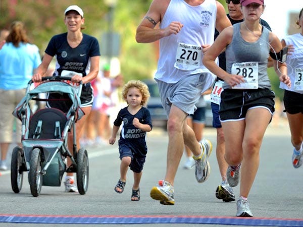 Chumpi Boyer, 3, of Peru jumps out of his mother’s stroller to finish the 27th annual Tri-Span 10k/5k Race with his uncle, Bill Boyer, and mother, Susan Boyer, who ran the whole race Saturday morning in downtown Wilmington.
