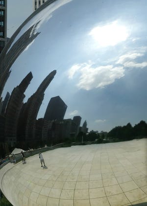 In this file photo, the hot sun over the Chicago skyline is reflected in Millennium Park's "Cloud Gate" sculpture. (AP Photo/Julio Cortez, file)