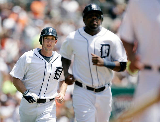 Detroit Tigers' Clete Thomas (left) trails Marcus Thames and Miguel Cabrera (not shown) to home plate following his three-run home run against the Cleveland Indians in the fourth inning of Sunday's baseball game in Detroit, Sunday.
