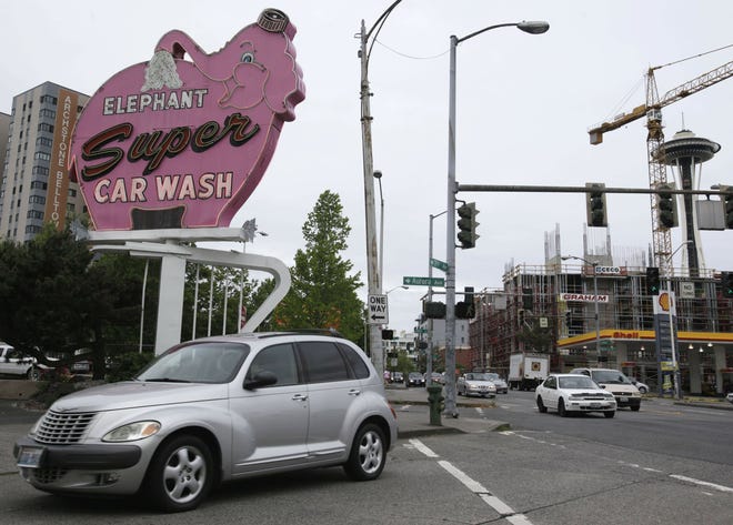 Seattle’s famous Elephant car wash is shown with the Space Needle in the background. One of the great American summer pastimes, washing the car in the driveway, may be in jeopardy as officials in Washington and elsewhere are hoping to implement new rules to prevent driveway runoff reaching streams and rivers and harming aquatic life.