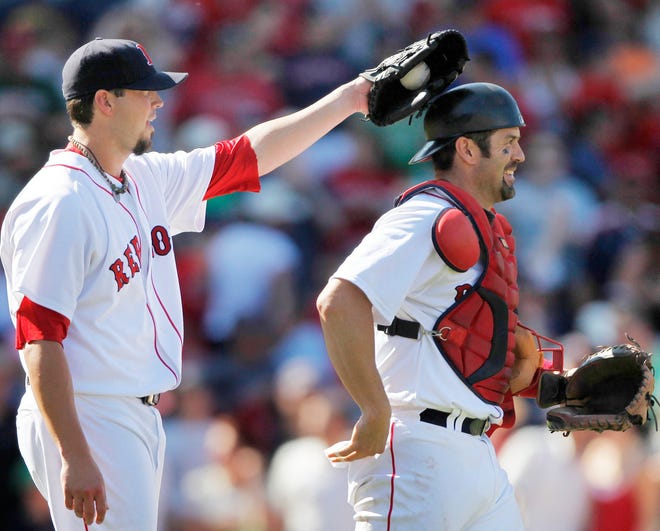 Red Sox pitcher Josh Beckett (left) taps catcher Jason Varitek on the helmet after Beckett threw a three-hit shutout in Boston's 6-0 win over the Royals.