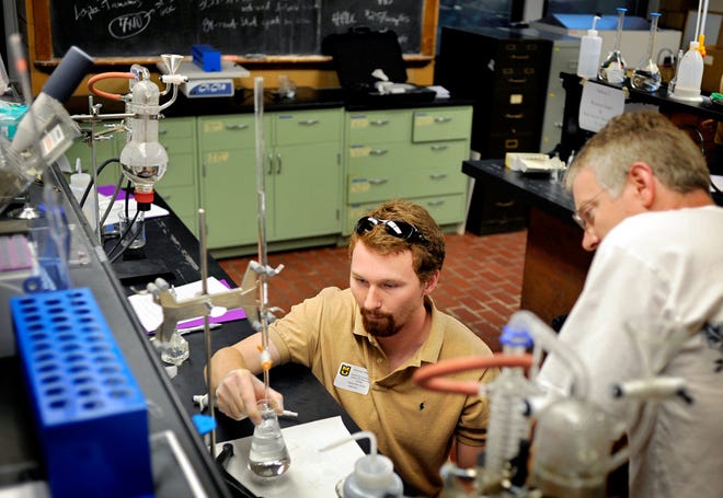 Phillip Price of Fayetteville, Tenn., holds a beaker as Jerry Judson of Kansas City watches while they measure the amount of acid, or vinegar, in a wine sample Tuesday at the Missouri Wine School workshop at Eckles Hall on the University of Missouri campus.