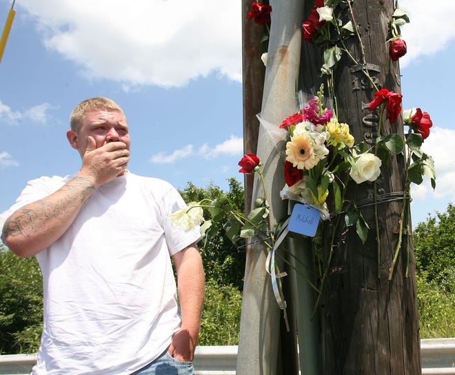 Best friend Colton Eliasen cries as he visits a memorial on Route 138 in Raynham at the site of Saturday's motorcycle crash that killed Mitchell Campbell of Randolph.