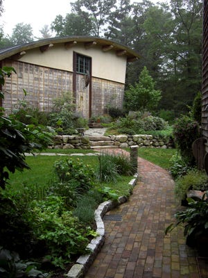 The curves of the path echo the flowing lines of the studio at this Norwell garden.
