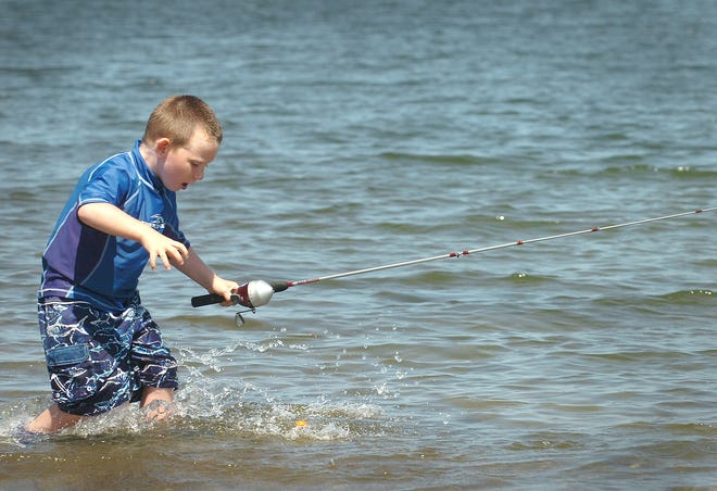 Joey Manton, 4, tries to grab his lure as he reels in his line at the Mound Street Beach in Quincy.