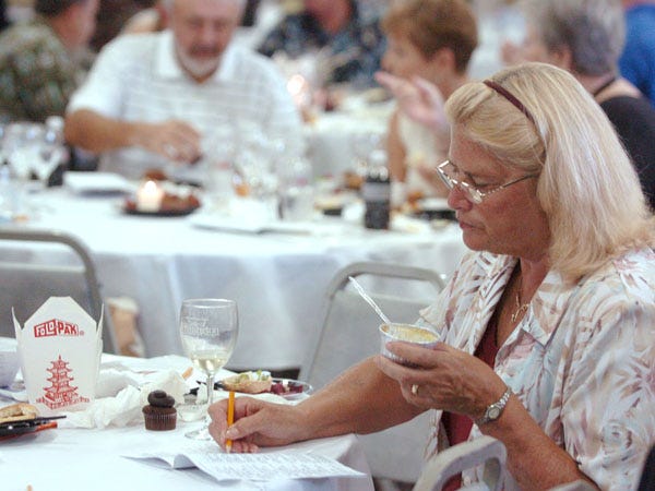 Trudy Barnes makes notes while tasting food at the StarNews and Wilmington Magazine Taste of Wilmington, showcasing more than 30 local businesses, at the Coastline Convention Center Sunday.