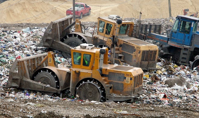 Bulldozers level piles of trash at the Winnebago Landfill on Wednesday, July 22, 2009.