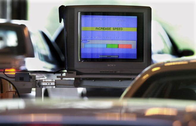 A computer monitor directs an employee to increase the car's speed for an emissions test at a motor vehicle inspection station in Lawrence Township, N.J.