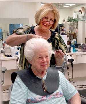 Putting the finishing touches on B.J. Wilkins’ hairstyle is Janice Bartholomew, owner of Just Hair Styling Centre in North Canton.