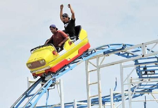 Lalo Serrano, left, and Eddu Hernandez, both of Rockwell Amusements, test out one of the roller coaster cars.