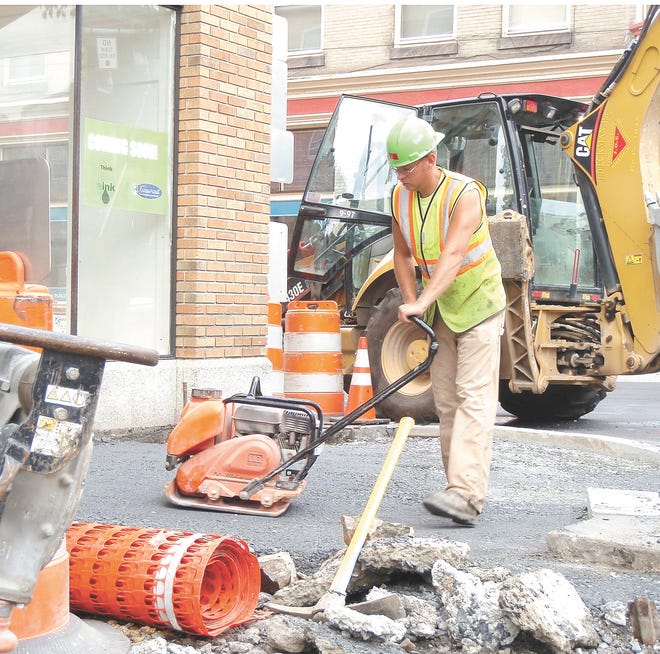 A crew member from GRC General Contractor Inc. smooths a portion of the sidewalk at the corner of South Potomac and West Main streets this morning. Crews are cutting through the south side of Main Street sidewalks to Center Square in the first phase of a three-phase brick sidewalk project made possible with a $500,000 state grant secured by former state Sen. Terry Punt.