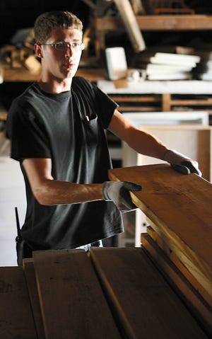 Evan Bruner, a yard man at People's Do It Center, moves lumber in the lumber yard section of the Galesburg business.