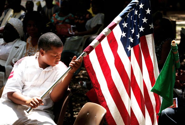 Joel Calhoun, 11, rolls up the American flag after performing in a flag ceremony at the Homowo festival at Monteocha Park Aug. 1, 2009. Calhoun is a member of the Flossie B. McClendon Drill Team.