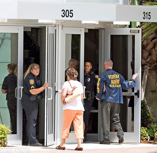 Ocala Police officers answer customer questions and guard the front doors of the Platinum Community Bank as numerous Federal agents descended onto Taylor, Bean & Whitaker Morgage Corp. at the Platinum Financial Center and Platinum Community Bank Monday morning August 3, 2009.