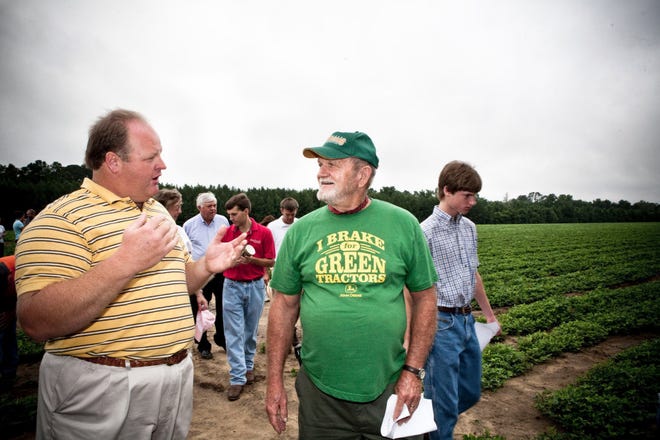 Michael Morgan explains to Wendell Shearouse the planting cycle of peanuts Saturday during the annual Effingham Young Farmer tour. (Misty DeBlasio/For Effingham Now)