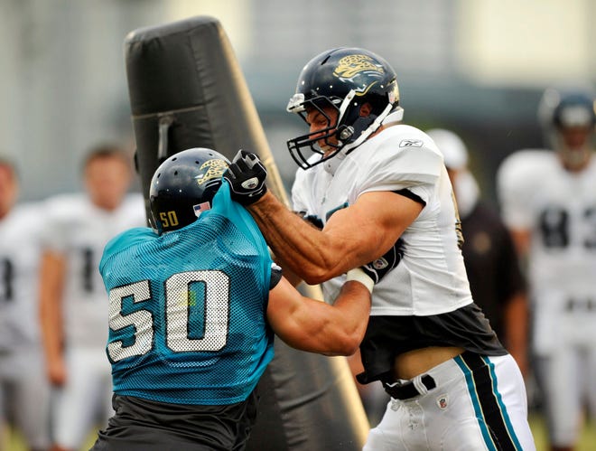 ANDY JACOBSOHN/The Times-UnionJaguars linebacker Russell Allen (left) and tight end Richard Angulo struggle during the Oklahoma drill in the night practice on the third day of training camp at the practice fields adjacent to Jacksonville Municipal Stadium on Wednesday.