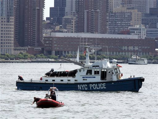 Emergency workers are seen looking for debris in the Hudson river in New York, Saturday, Aug. 8, 2009, after a helicopter and small plane crashed into each other in midair. The accident happened just after noon between Manhattan and Hoboken, N.J.