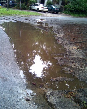 Water and soil accumulate quckly on East 54th Street after a hard rain. The City Council on Thursday will consider spending $860,000 to complete curb, gutter and sidewalk work along the street. (Courtesy of Therea Viselli)