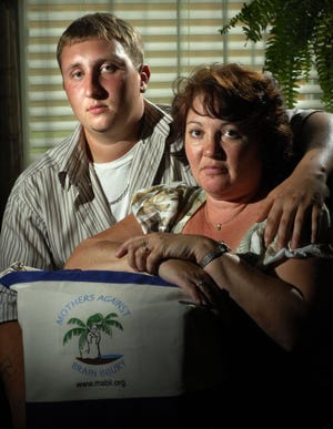 WILL DICKEY/The Times-UnionTracy Porter with her son Justin East, 22, in their St. Johns County home. He suffered a brain injury in a car wreck when he was 16. Porter has a program providing tote bags with supplies to family members of traumatic brain injury patients.