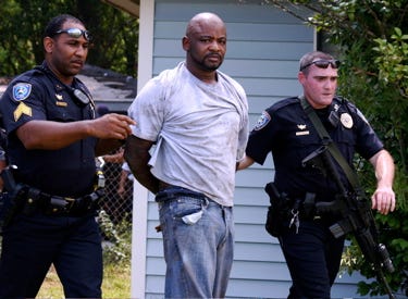 Gonzales Police officers detain Percy James Cage, who authorities want to question about a multiple homicide case in Baton Rouge. Authorities found Cage at 231 North Pleasant Ave., Gonzales.