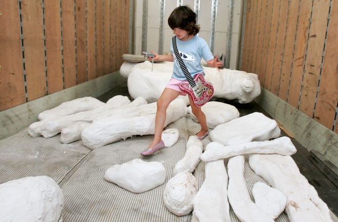Samantha Freeman, 6, makes her way though pods containing dinosaur bones after taking photos on the semitrailer that transported more than 120 dinosaur bones collected from the Hanksville-Burpee Quarry in Hanksville, Utah.