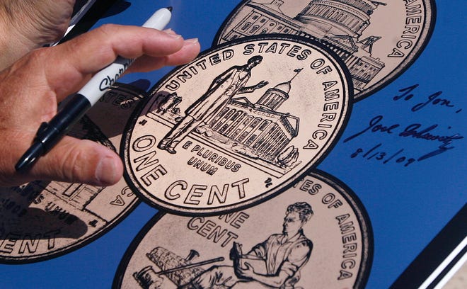 2009 Lincoln penny designer Joel Iskowitz holds a Sharpy marker after signing his autograph on a commemorative "Good Cents" poster designed by Springfield Artist Jonathan Benning after the unveiling ceremony.