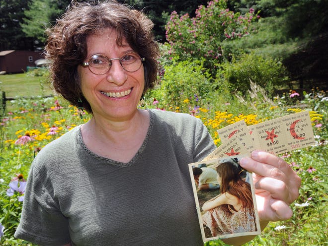 Jeanne Holtzman of Franklin holds original Woodstock tickets and a photo of herself in 1969.