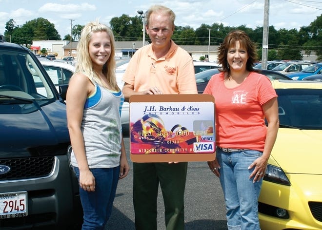 First to receive the J.H. Barkau & Sons Stimulus $500 gift cards were mother and daughter Cheryl, right, and Casey Wells. Pat Gillespie of J.H. Barkau presented the Wells with a replica of the gift card. Cheryl purchased a bright yellow Mazda RX8. Casey bought a Ford Escape.