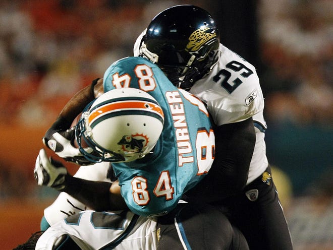 Miami Dolphins' Patrick Turner is tackled by Jacksonville Jaguars' Reggie Nelson and Brian Williams after he gained a second-quarter first down. (AP Photo/J Pat Carter)