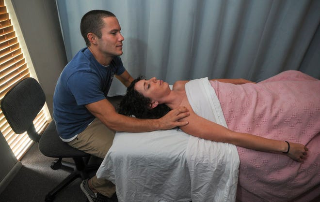 Monty Martin gives Penny Henderson a massage at the Savannah School for Massage Therapy. (Steve Bisson/Savannah Morning News)