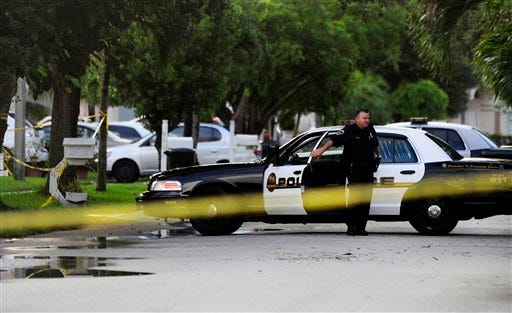 Miramar Police are seen near a home Tuesday, Aug. 18, 2009, where multiple slaying victims were discovered Monday afternoon in Miramar, Fla. Few details were immediately available about the grisly scene in Miramar on Monday. Investigators weren't saying how many were dead _ only that multiple bodies were recovered. The only living survivor was found outside the home in "extremely critical condition" after being shot in the face.
