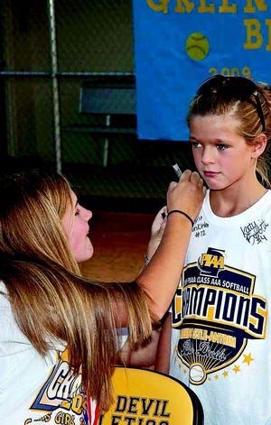 Greencastle-Antrim Blue Devil softball player Autumn Appleby signs the championship shirt of Megan Beam during a recognition night held for the 2009 Class AAA state champs Friday.