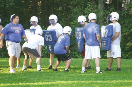 Kennebunk High assistant coach Rob Sullivan works with the offensive and defensive linemen during Tuesday morning's practice.