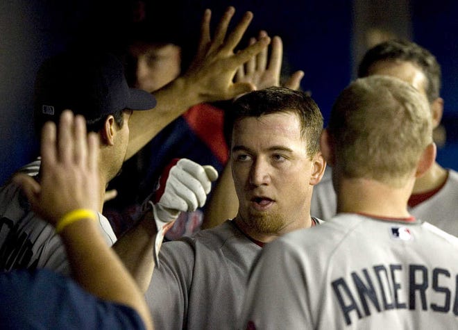 Boston’s J.D. Drew celebrates with his teammates in the dugout after hitting a two-run homer in the fourth inning.