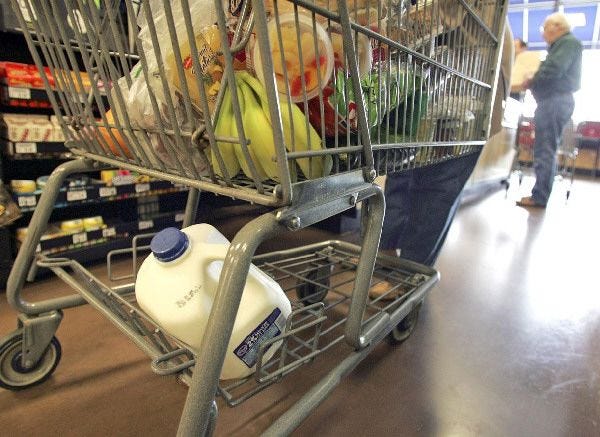 A cart full of groceries sits at the check-out counter at a Kroger store in Gahanna, Ohio. Shoppers in stores - and online - are increasingly ditching items after thinking twice about their purchase.