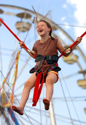 Seven-year-old Jillian Stanton of Braintree smiles as she takes a bungee ride at last year's Marshfield Fair. The 2009 fair is open for business this weekend.