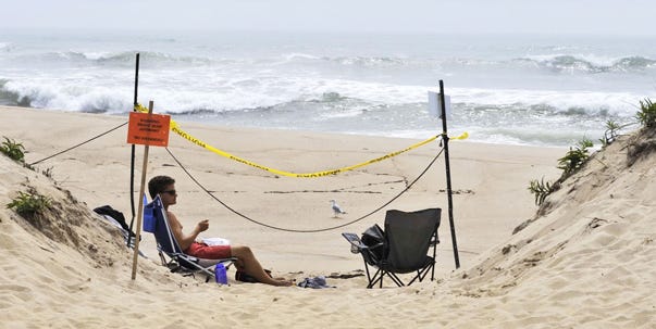 A lifeguard monitors South Beach on the Vineyard, which is closed because of Hurricane Bill. The island expects another high-profile visitor today: President Obama.