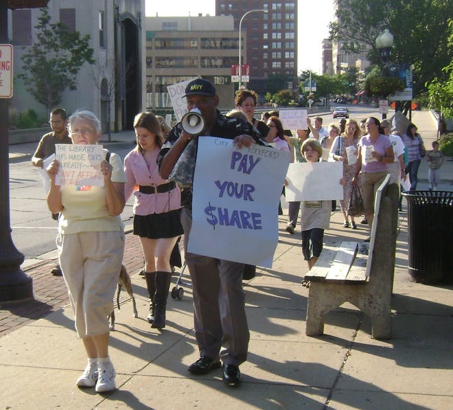 Rockford resident and activist Prophet Yusef leads about two dozen library supporters in a march down State Street before the Rockford City Council meeting Monday, Aug. 24, 2009. They were protesting proposed budget cuts that would reduce library hours, close the Lewis Lemon Branch and lay off 30 library staffers.