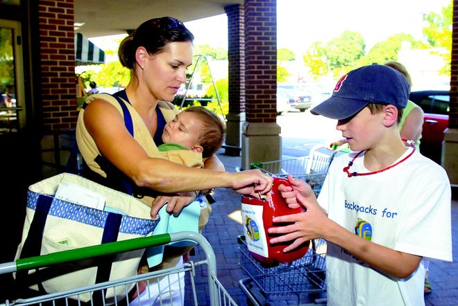 Jackson (shown), 10, and Tristan, 8, Kelley are West Roxbury residents. They have started "Backpacks for New Beginnings" a non-profit orginization dedicated to providing new backpacks and school supplies to children in need, Nicole Hazen holding Teddy, 11 months, makes a donation outside of Roche Bros in West Roxbury on Wednesday, August 19. Started about two weeks ago the boys have already donated over 70 backpacks.