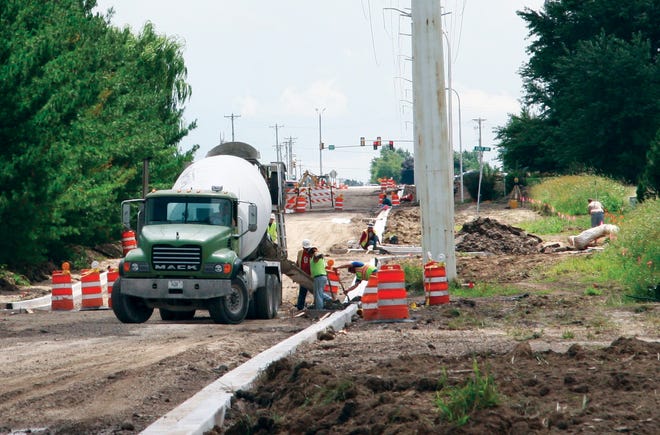 Workers lay curbs on North Cummings Lane, as part of the $890,000 project to reconstruct the roadway, install a new storm sewer infrastructure and add sidewalks on either side of the street. The Construction is behind schedule because of rain and other factors.